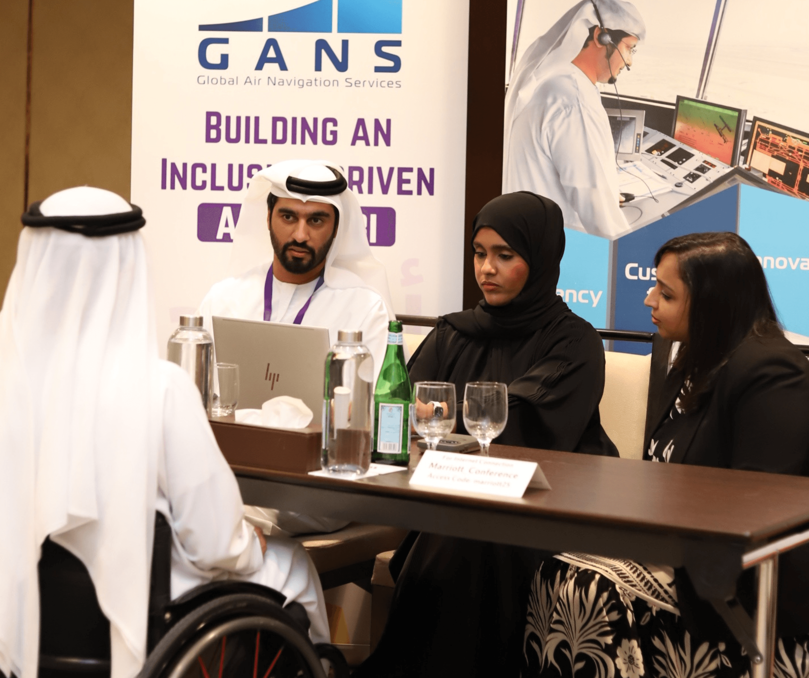 Panel discussion with participants in Middle Eastern dress at GANS 'Building an Inclusive-Driven' event, including wheelchair users. - Image 1 of 1